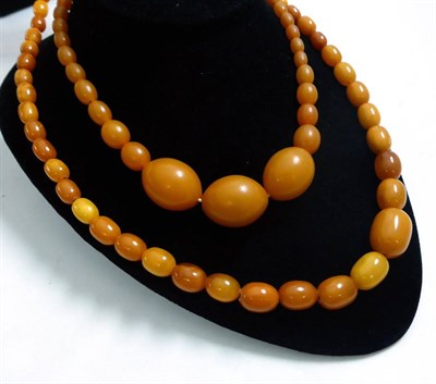 Lot 245 - An amber necklace and a simulant amber necklace