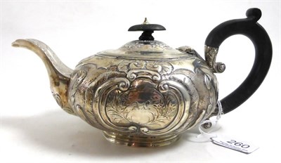 Lot 260 - A George III silver teapot, London 1777, with chased foliate decoration and a crest