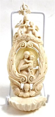 Lot 274 - A late 19th century ivory stoop, carved with Mary and Jesus, with a shell font and suspension loop