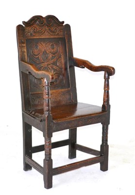 Lot 853 - A Joined Oak Armchair, the foliate carved and domed top rail above a fielded back support, with...