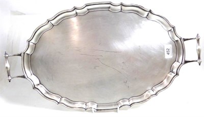 Lot 452 - A silver oval tray RB & SL Birmingham 1930, with moulded rim and twin scroll handles, 56ozt