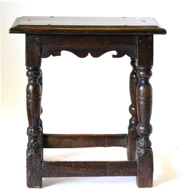 Lot 865 - An English Joined Oak Stool, circa 1640, the six-pegged rectangular moulded top above a carved...