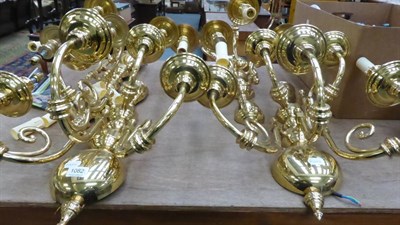 Lot 1082 - A pair of modern brass five-light wall lights