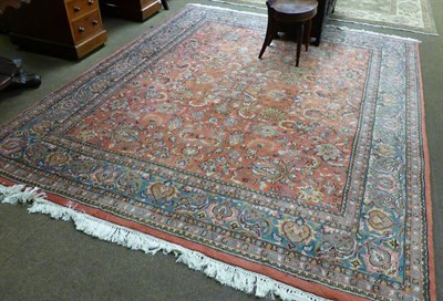 Lot 1299 - An Indian carpet of unusual size, the terracotta field with an allover design of palmettes, flowers