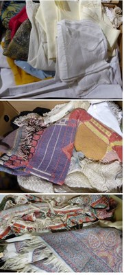 Lot 1376 - Assorted white damask linen cloths, woven and printed textiles, aprons, black ostrich feather...