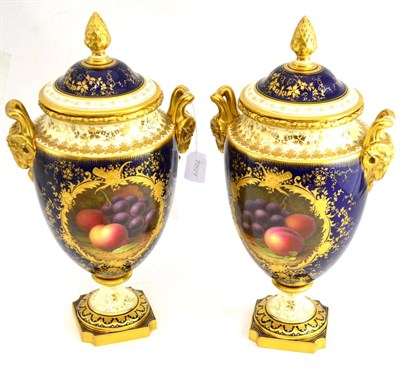 Lot 40 - A pair of fruit-painted Coalport vases and covers, by F.Howard with gilt ram handles and highlights