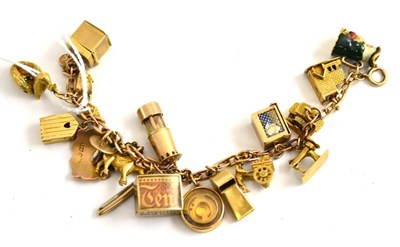 Lot 69 - A bracelet hung with charms, mainly 9ct gold, including a first aid box and a puzzle game