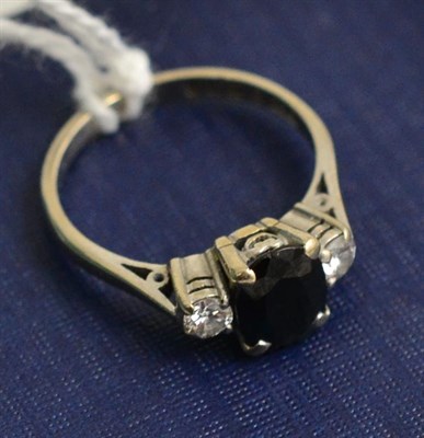 Lot 240 - An 18ct white gold sapphire and diamond three stone ring (sapphire chipped)