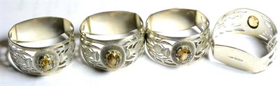 Lot 275 - Set of four silver and hardstone napkin rings, Joseph Cook & Son Birmingham 1931, pierced with...