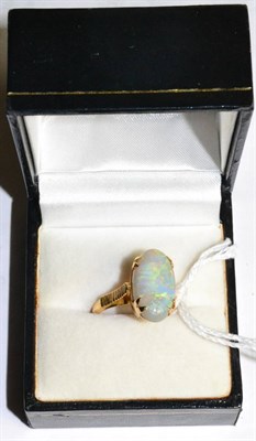 Lot 288 - An opal ring, the oval cabochon opal in a claw setting to linear decorated shoulders on a plain...