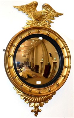 Lot 971 - A Regency Style Gilt and Gesso Convex Mirror, late 19th century, with ebonised slip and ball...