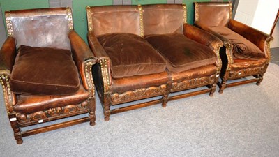 Lot 1134 - Early 20th century carved oak three piece suite with dark leather upholstery