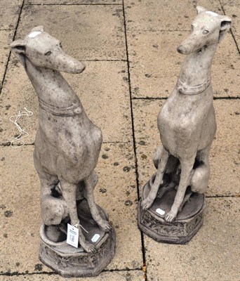 Lot 1160 - Pair of stone cast sculptures of whippets seated on an octagonal base, 80cm high