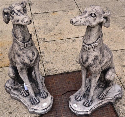 Lot 1161 - Pair of greyhounds seated on a shield shaped base, 81cm high