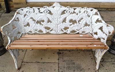 Lot 1173 - A Coalbrookdale style cast iron garden bench, cast and pierced with ferns and strapwork, slat seat