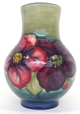 Lot 67 - A Walter Moorcroft Clematis Pattern Vase, on a blue/green wash ground, impressed factory marks...