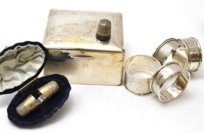 Lot 108 - A group of silver objects including a small cigarette box, four napkin rings and a pair of thimbles