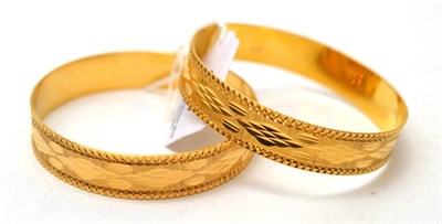 Lot 117 - Two fancy bangles, stamped '750', purchased in Libya