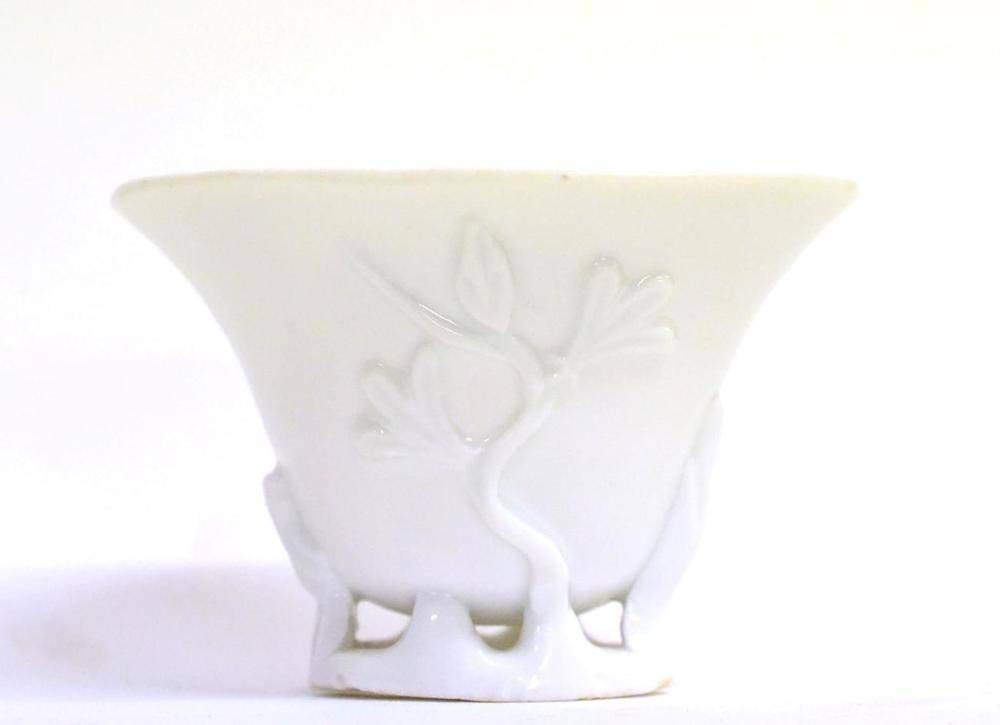Lot 60 - A Blanc de Chine Libation Cup, Kangxi, of ovoid form, moulded with flowering branches on a...