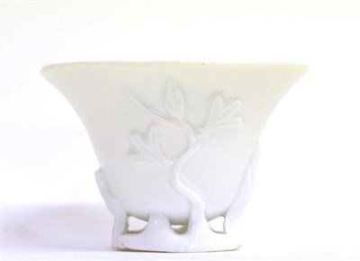 Lot 60 - A Blanc de Chine Libation Cup, Kangxi, of ovoid form, moulded with flowering branches on a...