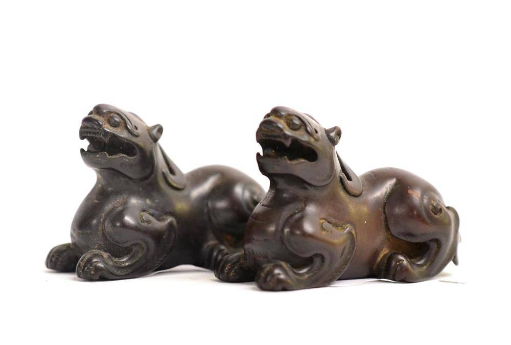 Lot 78 - A Pair of Chinese Carved Hardwood Figures of Lion Dogs, Qing Dynasty, recumbent with scrolling...
