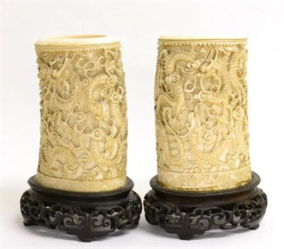 Lot 79 - A Pair of Chinese Ivory Tusk Vases, mid 19th century, carved with dragons above a pagoda, on carved