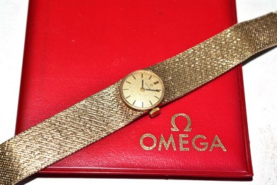 Lot 355 - Lady's Omega wristwatch on 9ct gold strap with original Omega booklet