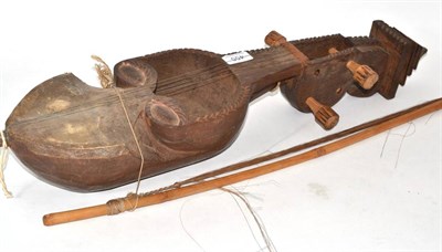 Lot 455 - An African hardwood stringed instrument, the sound bowl carved as a mask, with bow