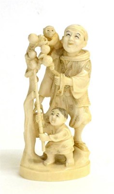 Lot 105 - A Japanese Ivory Okimono of a Street Entertainer, Meiji period, standing, a monkey on his shoulder