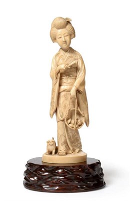 Lot 108 - A Japanese Ivory Okimono of a Girl, Meiji period, standing wearing traditional flowing robes...