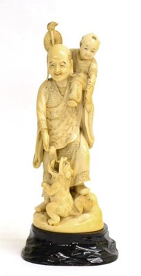 Lot 110 - A Japanese Ivory Okimono of a Man, Meiji period, standing wearing traditional costume, his son...