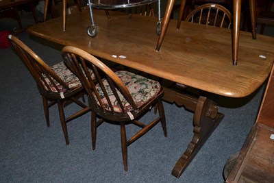 Lot 1077 - A modern Ercol dining table with six chairs