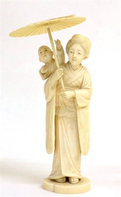 Lot 114 - A Japanese Ivory Okimono, Meiji period, as a mother holding a parasol, her son on her shoulder,...