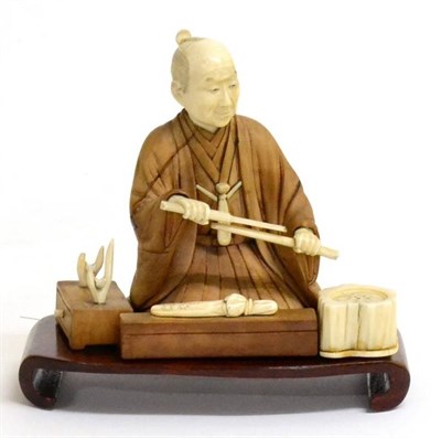 Lot 116 - A Japanese Ivory, Hardwood and Mother-of-Pearl Okimono, Meiji period, as a sword maker kneeling...