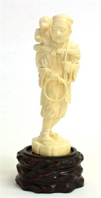 Lot 117 - A Japanese Ivory Okimono as a Farmer, Meiji period, wearing traditional clothes, a monkey on...