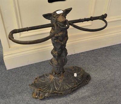 Lot 1123 - A cast iron stick stand in the form of a dog holding a crop