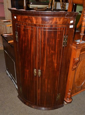 Lot 1322 - George III bow fronted mahogany corner cupboard