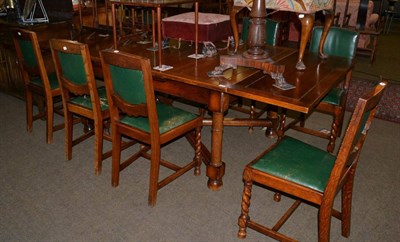 Lot 1331 - An Edwardian oak draw leaf table and eight oak dining chairs with barley twist supports and drop-in