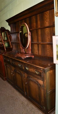 Lot 1401 - An 18th century style panelled oak dresser and rack