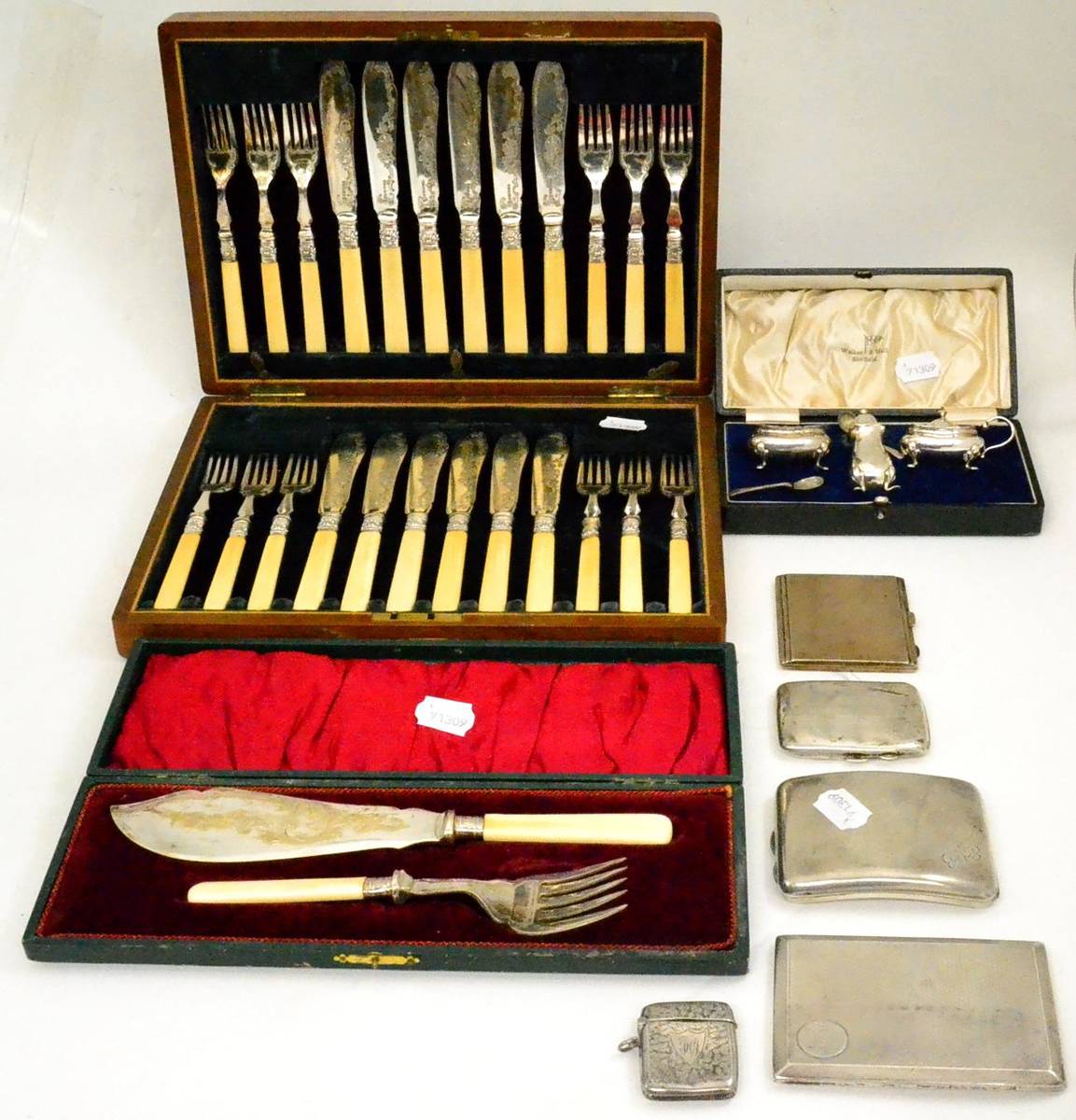 Lot 24 - A silver vesta, four cigarette cases, a plated cruet set, a set of fish servers and a cased set...