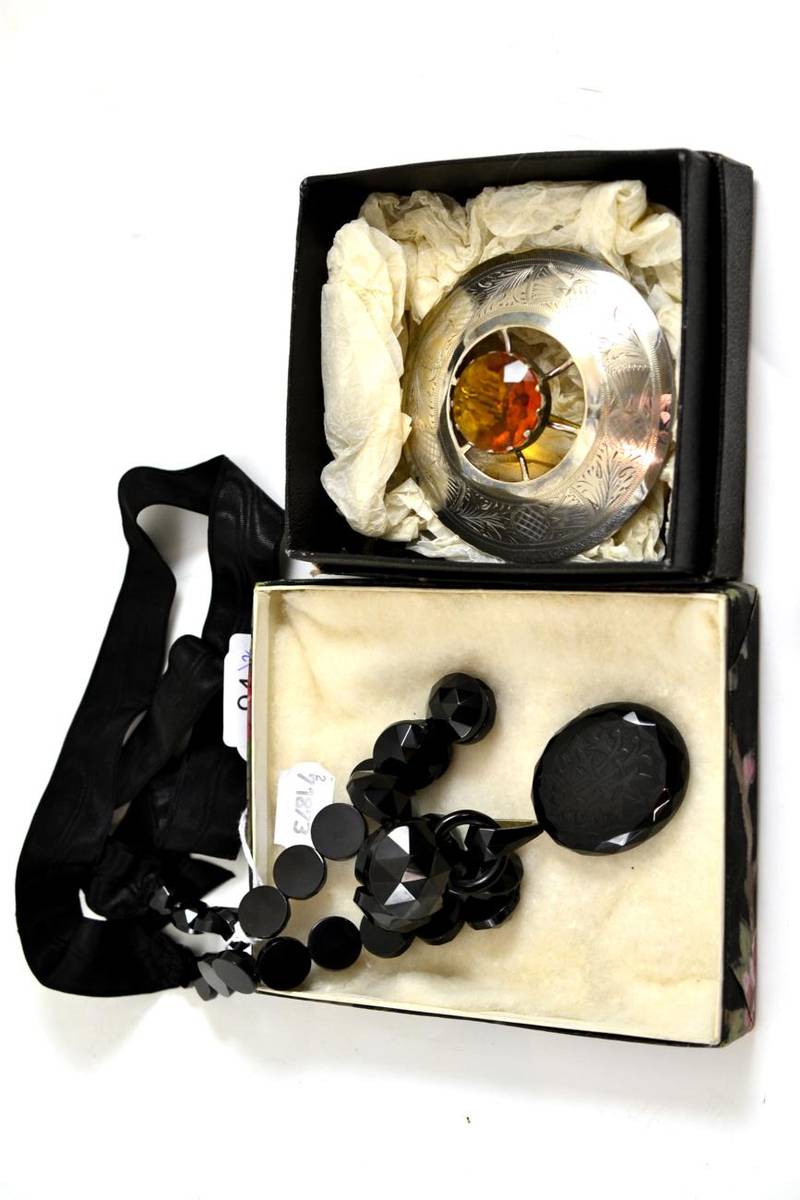 Lot 94 - Whitby jet pendant on chain with silk ribbon and plated Scottish brooch (2)