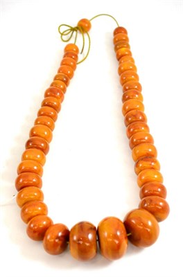 Lot 249 - A string of amber-coloured beads