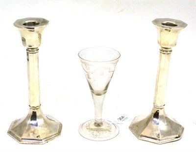 Lot 264 - Georgian trumpet ale glass with engraved decoration and pair of loaded silver candlesticks (3)