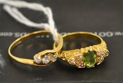 Lot 313 - An 18ct gold peridot and diamond ring and a diamond three stone twist ring (2)