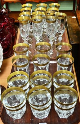 Lot 411 - A suite of gilt decorated cut glass, including wine glasses, champagne flutes, tumblers a jug etc