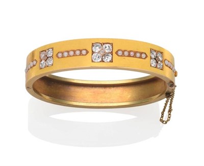 Lot 207 - A Diamond and Seed Pearl Bangle, inset with three clusters of five old cut diamonds in yellow...