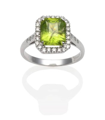 Lot 236 - An 18 Carat White Gold Peridot and Diamond Cluster Ring, an emerald-cut peridot in a white claw...