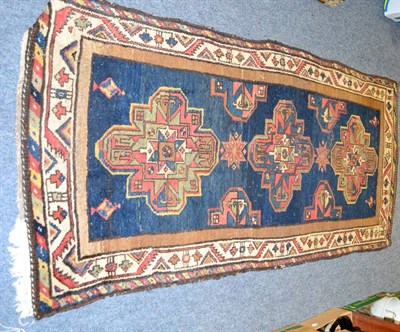 Lot 1156 - A 19th century Kurdish rug, Persian Kurdistan, the indigo field with three guls enclosed by...