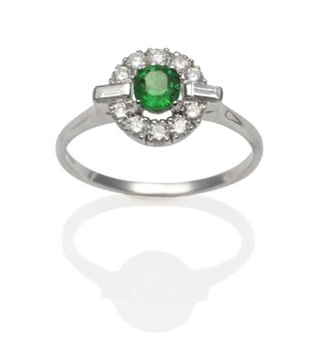 Lot 240 - An 18 Carat Gold Green Garnet and Diamond Cluster Ring, a round cut green garnet within a border of