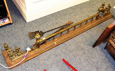 Lot 1193 - Victorian fender with brass figural mounts and three fire irons